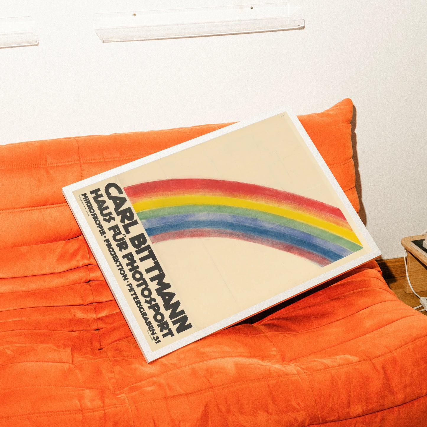 Minimalistisches Vintage-Plakat mit einem großen bunten Regenbogen und schwarzer Typografie unten.